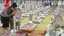 Warga mencium batu nisan di makam Hasri Ainun Besari yang bersebelah dengan makam sang suami,  Presiden ke-3 RI BJ Habibie di TMP Kalibata, Jakarta, Jumat (13/9/2019). Sesuai permintaannya semasa hidup, BJ Habibie dimakamkan bersebelahan dengan mendiang istrinya Ainun. (Liputan6.com/Herman Zakharia)