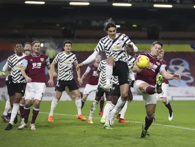 Penyerang Manchester United, Edinson Cavani berebut bola saat menghadapi Burnley dalam partai tunda Liga Inggris 2020/21 di Turf Moor, Rabu (13/1/2021) dini hari WIB. Manchester United sukses mengalahkan Burnley dengan skor tipis 1-0. (Clive Brunskill/Pool via AP)