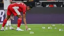 Hal tersebut sempat menunda pertandingan karena gelas dan botol plastik tersebut masuk ke dalam lapangan pertandingan. (AP Photo/Ali Issa)