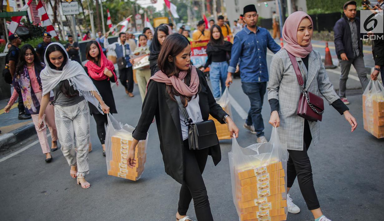 Peserta aksi yang tergabung dalam Mahasiswa dan Pemuda Relawan Cinta NKRI membagikan takjil ke anggota Polri yang bertugas di Gedung Bawaslu RI, Jakarta, Minggu (26/5). Aksi simpatik sebagai wujud apresiasi kepada anggota Polri-TNI yang menjaga keamanan aksi 22 Mei 2019. (Liputan6.com/Faizal Fanani)