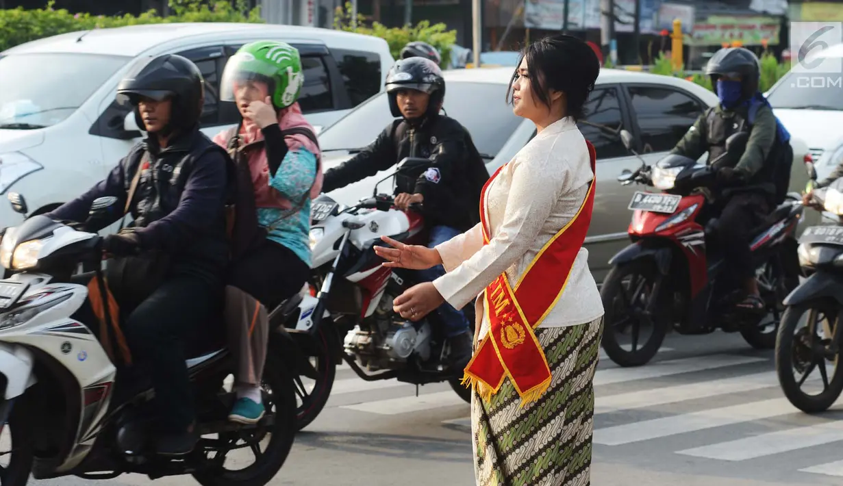 Personel Polisi Wanita (Polwan) Polres Jakarta Timur mengenakan pakaian kebaya saat mengatur arus lalu lintas di Jalan Otista Raya, Jatinegara, Jumat (20/4). Para polwan itu juga mengenakan selempang bertulisan Polres Jaktim. (Merdeka.com/Imam Buhori)