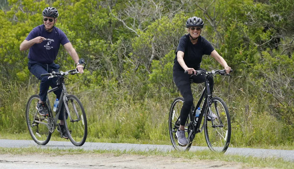 Presiden Joe Biden bersama ibu negara, Jill Biden bersepeda di Pantai Rehoboth, Delaware, Kamis (3/6/2021). Mereka bersepeda sekaligus untuk merayakan ulang tahun ke-70 ibu negara Amerika Serikat. (AP Photo/Susan Walsh)
