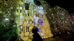 Karya pelukis Austria, Gustav Klimt dalam pameran seni proyeksi di galeri l'Atelier des Lumieres di Paris, Prancis (24/4). Pameran ini menampilkan terobosan baru yakni sebuah galeri digital yang diproyeksikan di sekitar gudang. (AP/Michel Euler)