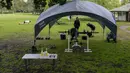 Orang-orang berolahraga di sebuah taman di pinggiran timur Sydney, pada 14 September 2021. Pelatih pribadi telah mengubah taman kawasan tepi laut di Rushcutters Bay Sydney menjadi gym luar ruangan untuk menyiasati pembatasan lockdown karena pandemi covid-19. (AP/Mark Baker)