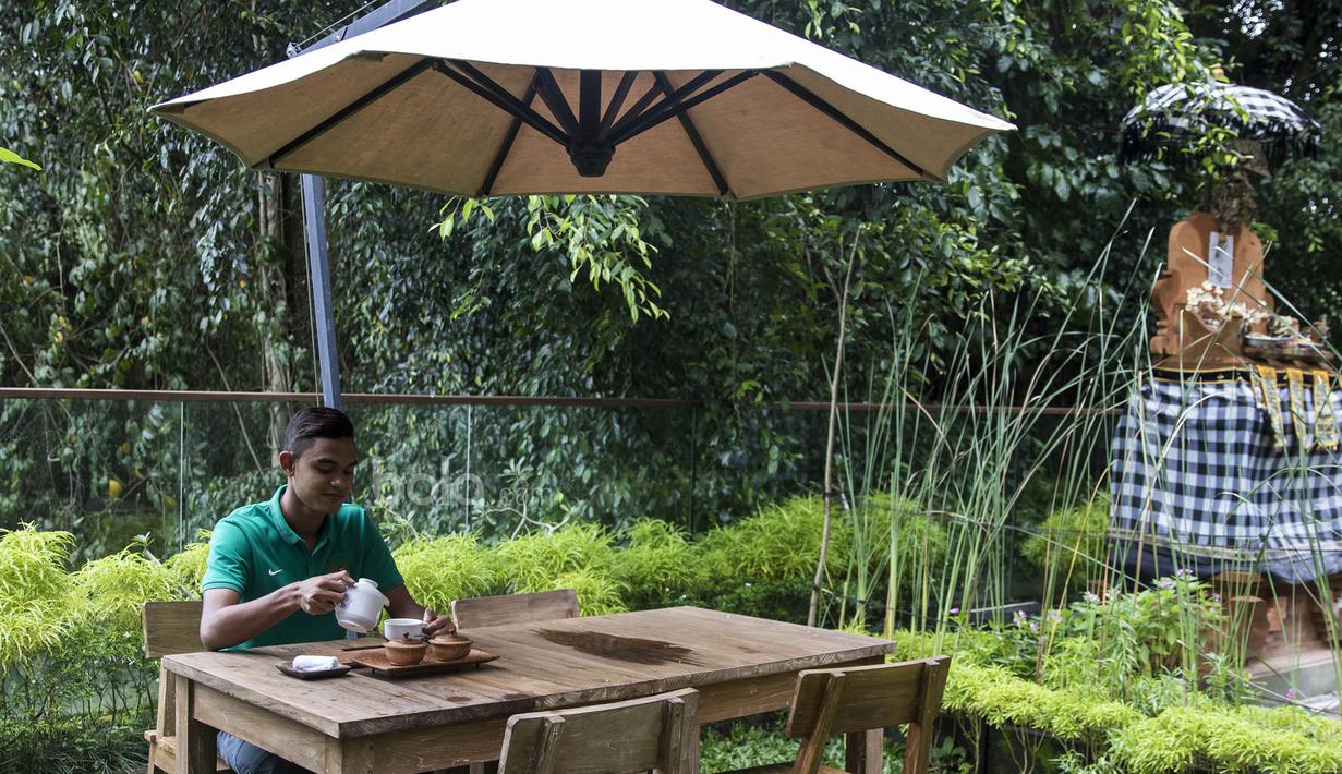 Gelandang Timnas Indonesia U-22, Miftahul Hamdi, mengisi waktu luang dengan menikmati secangkir teh di Hotel Sthala, Bali, Sabtu (8/7/2017). Pemain Bali United ini sedang mengikuti pemusatan latihan jelang SEA Games. (Bola.com/Vitalis Yogi Trisna)
