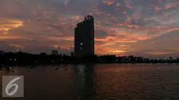Pemandangan saat matahari terbenam di akhir 2016 di Ancol, Jakarta, Sabtu (31/12). Sebagian masyarakat merayakan pergantian tahun baru di pesisir Jakarta untuk menikmati matahari terbenam. (Liputan6.com/Angga Yuniar)