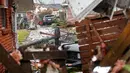 Seorang pria berjalan didekat puing-puing rumah yang rusak akibat dihantam Tornado di New Orleans, AS (7/2). Gubernur John Bel Edwards mengumumkan keadaan darurat untuk wilayah Louisiana. (AP Photo/Gerald Herbert)