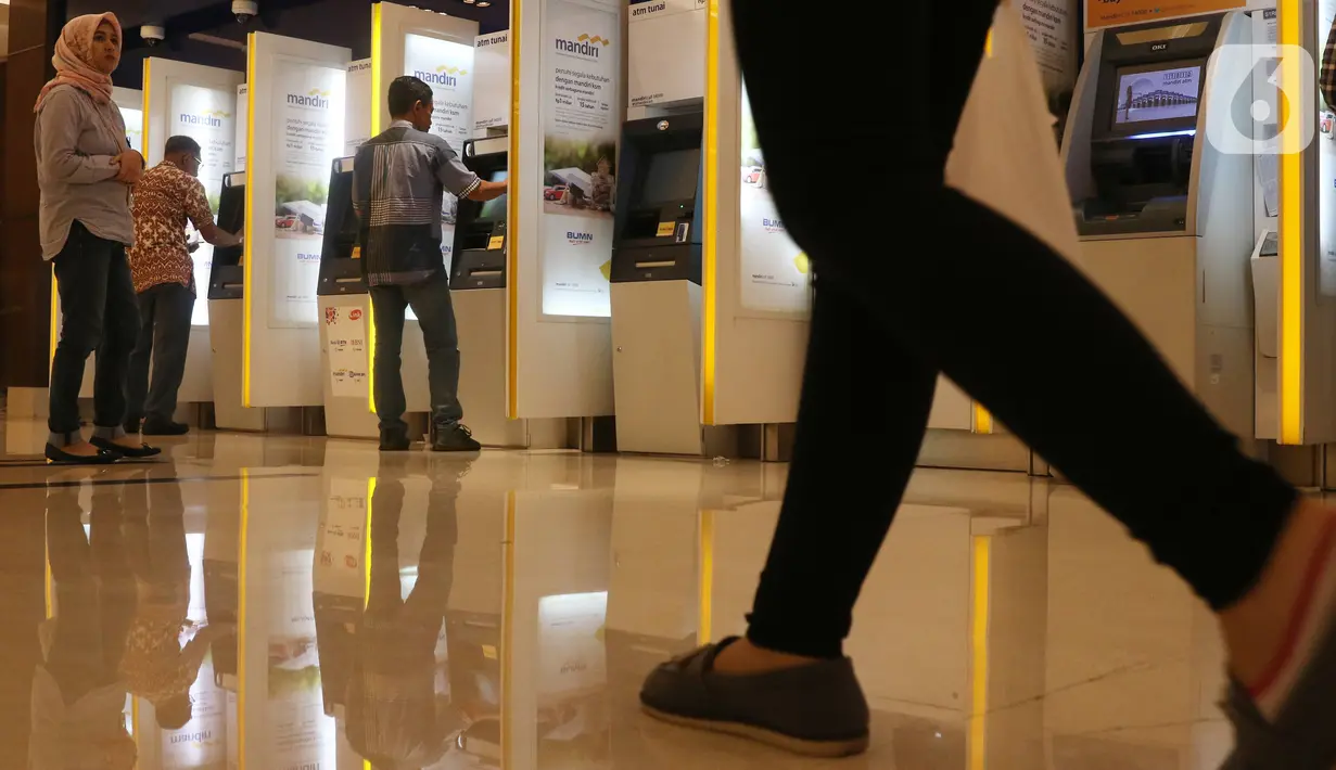 Nasabah melakukan transaksi elektronik perbankan melalui ATM di Jakarta, Selasa (4/2/2020). Transaksi kanal elektronik Bank Mandiri sepanjang 2019 juga terdongkrak naik empat persen secara yoy menjadi  Rp 2,1 miliar transaksi dengan nilai finansial sebesar Rp 3,1 triliun. (Liputan6.com/Angga Yuniar)
