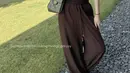 Berikutnya, Aaliyah mengenakan setelan coklat dari atasan tank top dipadukan celana panjang loose bertali sambil membawa tas Chanelnya. [@aaliyah.massaid]