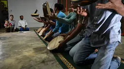 Pemuda mengikuti gladi bersih tari Rapa'i Geleng, menggunakan rebana tradisional, di desa ekowisata Nusa di Lhoknga, provinsi Aceh (31/8/2021). (AFP/Chaideer Mahyuddin)