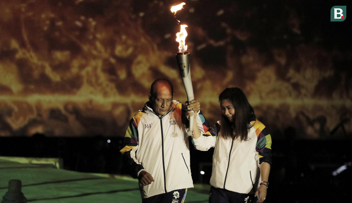 Legenda bulutangkis Indonesia, Susi Susanti dan mantan atlet tenis Yustedjo Tarik, saat prosesi kirab obor di Candi Prambanan, Rabu (18/7/2018). Api obor Asian Games tersebut akan dibawa mengelilingi 18 provinsi. (Bola.com/M Iqbal Ichsan)