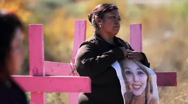 Carmen Castillo memegang foto mendiang putrinya Monica Delgado di pemakaman Juarez, Negara Bagian Chihuahua, Meksiko, (24/11). Aksi tersebut digelar jelang Hari Penghapusan Kekerasan Perempuan Internasional.(AFP Photo/Herika Martinez)