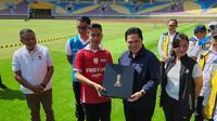 Ketua Umum PSSI, Erick Thohir, menyerahkan souvenir Piala Dunia U-20 2023 kepada Wali Kota Solo, Gibran Rakabuming Raka, saat mengunjungi Stadion Manahan, Solo, Minggu (12/3/2023). (Bola.com/Radifa Arsa)