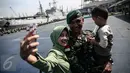 Seorang personel TNI-AD berselfie bersama keluarganya di Pelabuhan Kolinlamil, Jakarta, Senin (9/5). Sebanyak 450 personel TNI-AD dari Satgas Yonif Para Raider 330 inf 1 Kostrad dilepas untuk misi pengamanan perbatasan RI-PNG. (Liputan6.com/Faizal Fanani)