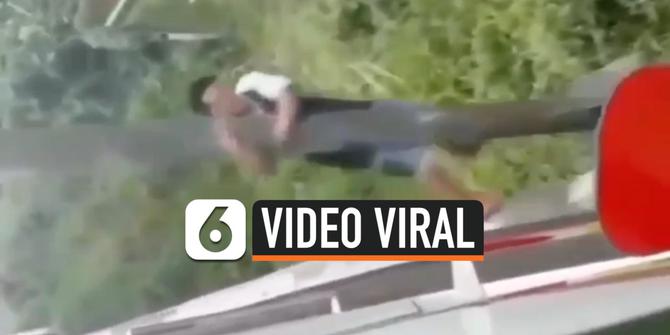 VIDEO: Video Viral Pemuda Bergelantungan di Tiang Jembatan KA