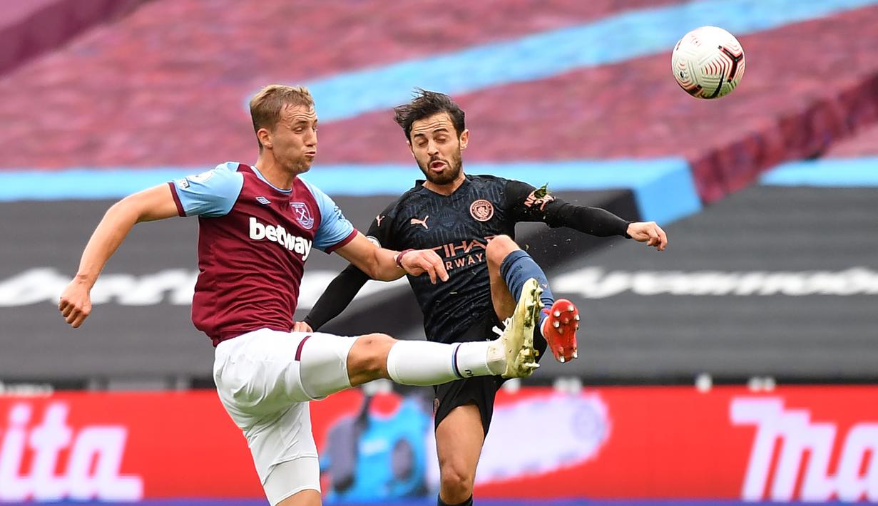 Gelandang Manchester City, Bernardo Silva, berebut bola dengan gelandang gawang West Ham United, Tomas Soucek, pada laga lanjutan Liga Inggris di London Stadium, Sabtu (24/10/2020) malam WIB. Manchester City imbang 1-1 lawan West Ham. (AFP/Justin Tallis/pool)
