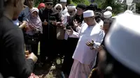 Penyanyi Opick berdoa di samping makam istri keduanya Wulan Mayasari di TPU Semper, Jakarta, Senin (19/3). Selama proses pemakaman ini, Opick didampingi oleh para santri dan kerabat dari perkumpulan komunitas bela diri. (Liputan6.com/Faizal Fanani)