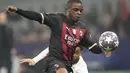 Bek AC Milan, Pierre Kalulu mengejar bola melewati pemain Tottenham, Arnaut Danjuma selama pertandingan leg pertama babak 16 besar Liga Champions di stadion San Siro di Milan, Italia, Rabu (15/2/2023). AC Milan menang tipis atas Tottenham dengan skor 1-0. (AP Photo/Luca Bruno)