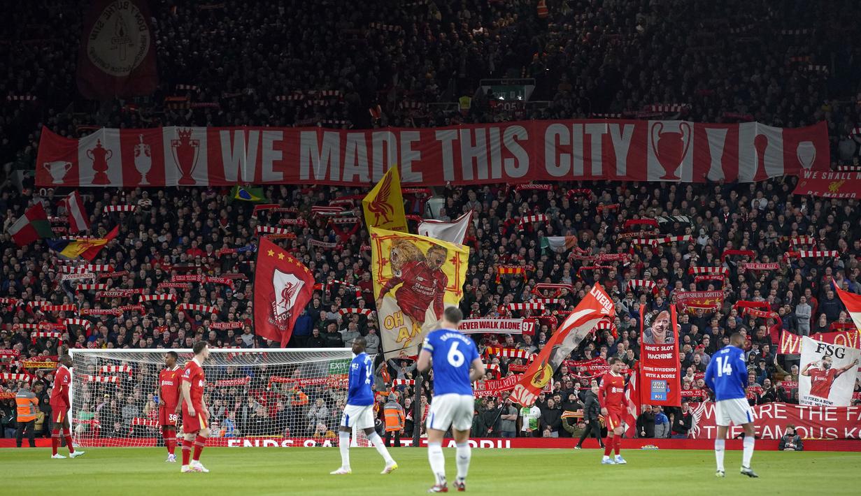 Para pendukung Liverpool membentangkan spanduk dan mengangkat syal dalam laga lanjutan Liga Inggris 2024/2025 melawan Everton di Anfield, Liverpool, Inggris, Rabu (02/04/2025) waktu setempat. (AP Photo/Ian Hodgson)