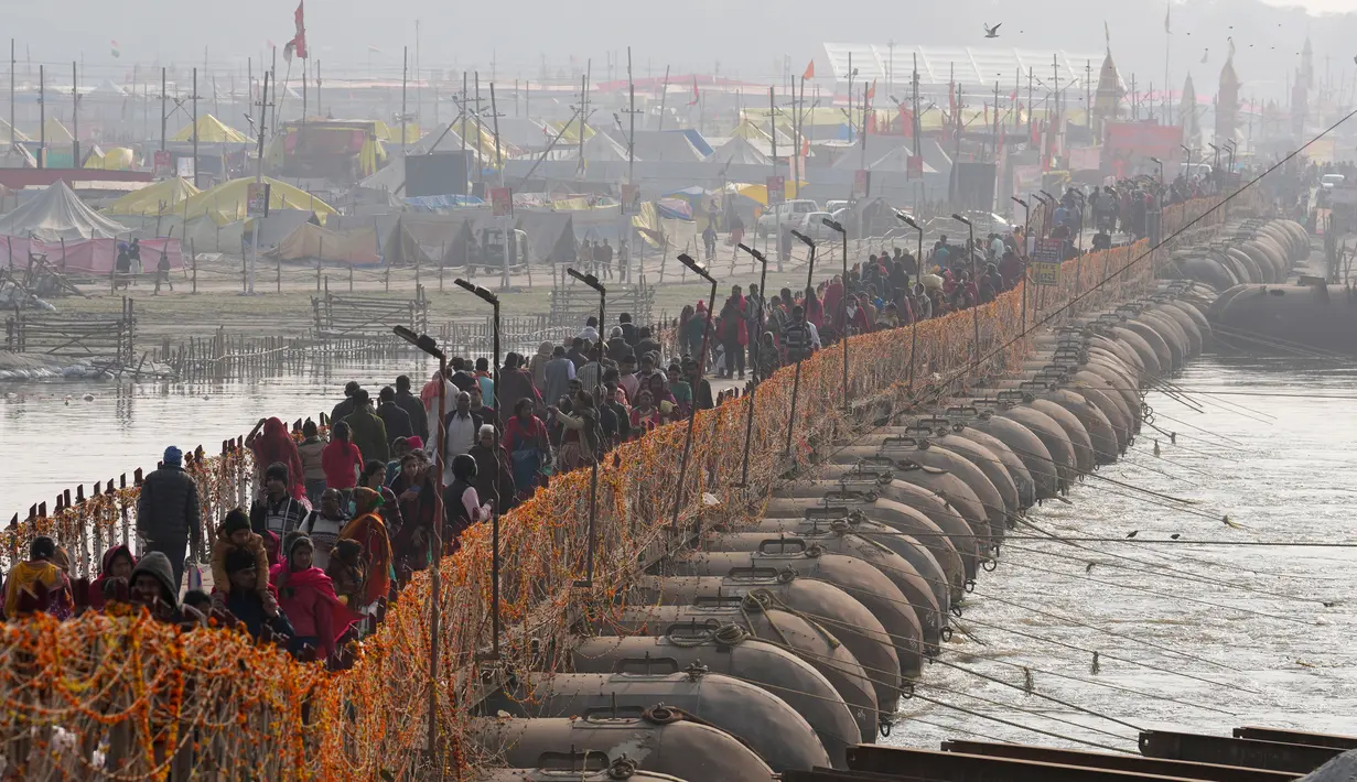 Umat Hindu membawa barang-barang saat tiba untuk berendam di Sangam, pertemuan Sungai Gangga - Sungai Yamuna, saat Festival Magh Mela di Prayagraj, Uttar Pradesh, India, 31 Januari 2023. Ratusan ribu peziarah Hindu diperkirakan akan berenang dalam pertemuan tersebut, berharap bisa menghapus dosa selama festival sebulan penuh. (AP Photo/Rajesh Kumar Singh)