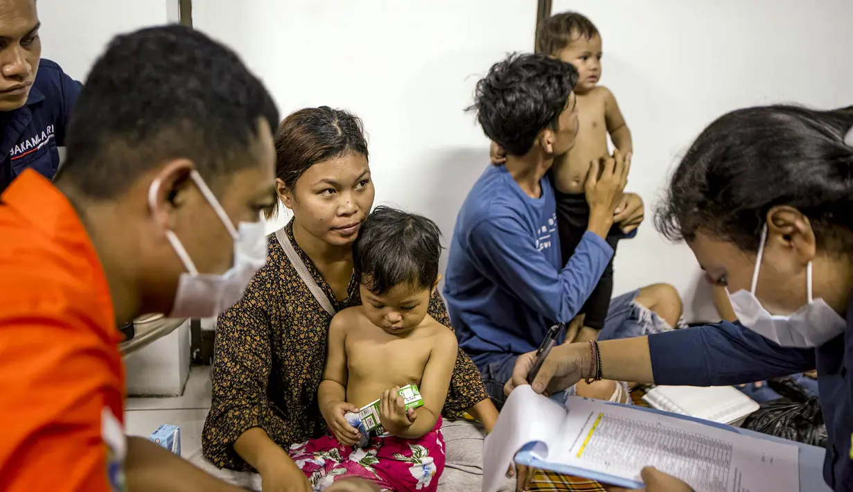 Petugas medis mengumpulkan data dan melakukan pemeriksaan kesehatan terhadap para penumpang kapal feri Putri Yasmin di Pelabuhan Padang Bay, Karangasem, Bali, Rabu, 12 Agustus 2026. (AFP/ Lana Priatna)