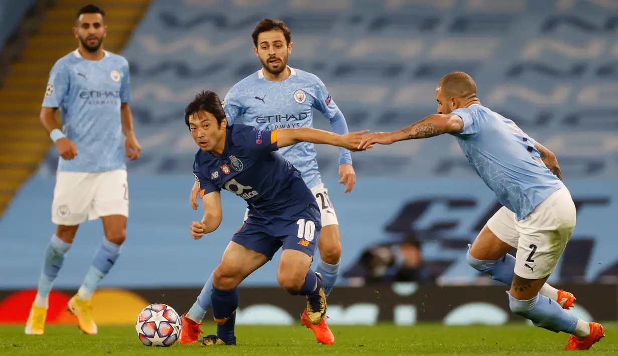 Penyerang FC Porto, Shoya Nakajima berebut bola dengan bek Manchester City, Kyle Walker pada matchday pertama Grup C Liga Champions di Etihad Stadium, Kamis (22/10/2020) dini hari WIB. Manchester City sukses menaklukan Porto dengan skor 3-1. (Phil Noble/Pool via AP)