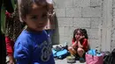 Anak-anak Palestina menunggu di dekat dapur umum yang membagikan makanan siap saji di kamp pengungsi Nuseirat di Jalur Gaza tengah pada 5 Mei 2025. (Eyad BABA/AFP)