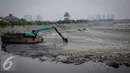 Sebuah alat berat dikerahkan untuk mengeruk sampah dari dasar Waduk Pluit, Jakarta, Senin (3/10). Sampah tersebut berasal dari bekas permukiman warga yang pernah mendiami wilayah tersebut. (Liputan6.com/Faizal Fanani)
