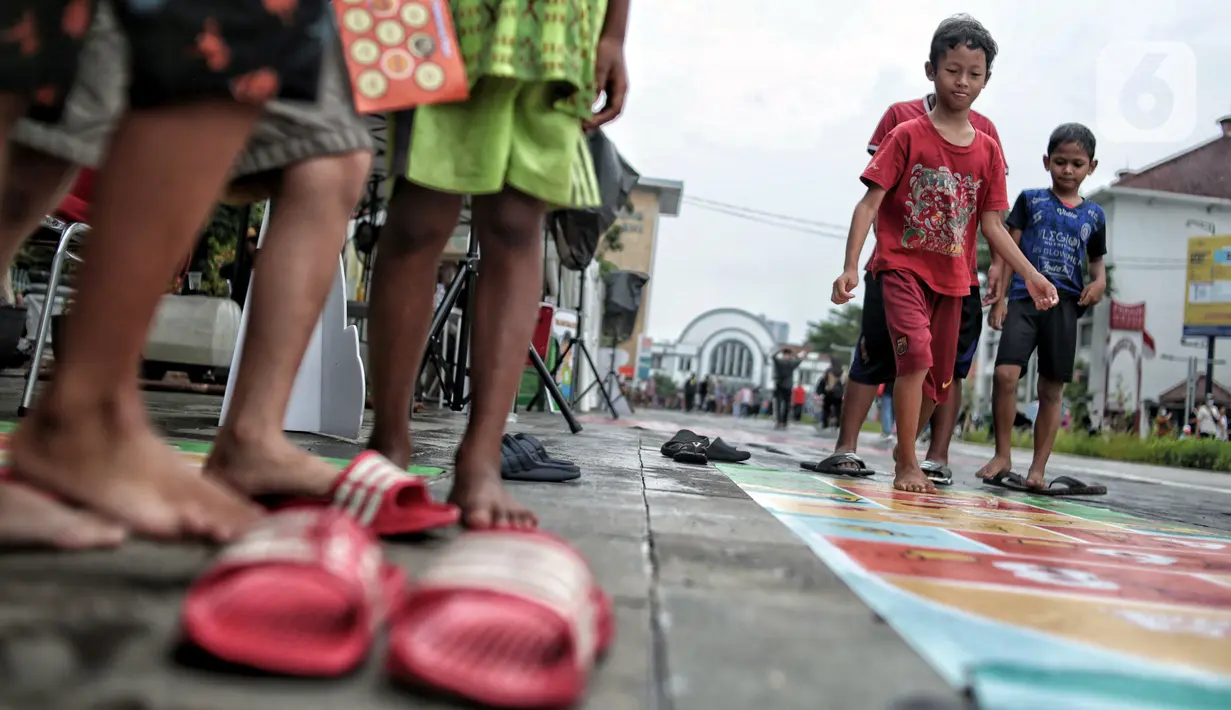 Anak-anak bermain permainan tradisional di kawasan Kota Tua, Jakarta Barat, Minggu (13/11/2022). Ada sembilan jenis permainan tradisional yang dihadirkan seperti rangku alu, gasing, kapal otok-otok, engklek, lompat tali, congklak, petak umpet, petak jongkok, dan bola bekel. (merdeka.com/Iqbal S. Nugroho)