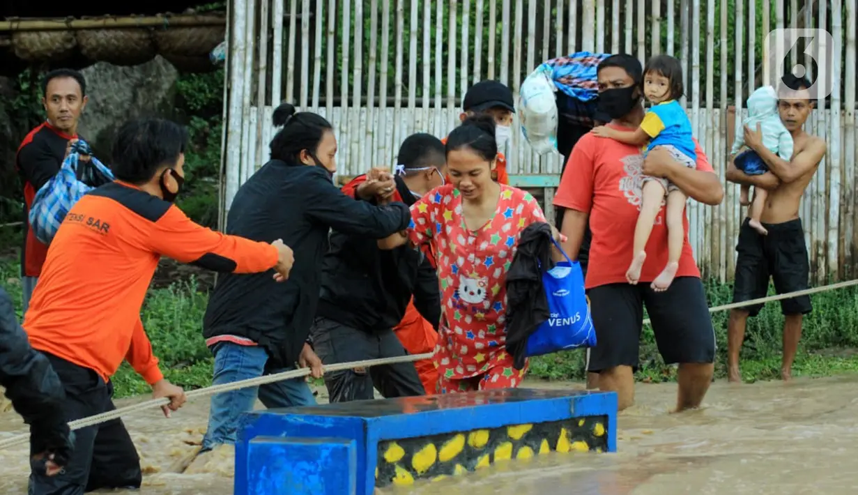 Petugas berusaha mengevakuasi warga saat banjir bandang  di Kabupaten Bone Bolango, Gorontalo (11/6/2020). Data sementara yang diterima dari BPBD Kabupaten Bone Bolango sekitar 1.078 kepala keluarga serta 5.407 jiwa terdampak banjir bandang. (Liputan.com/Arfandi Ibrahim)