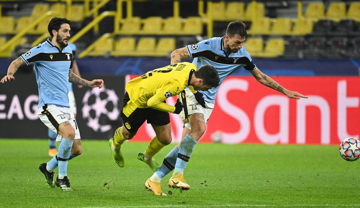 Gelandang Borussia Dortmund, Giovanni Reyna (tengah), berebut bola dengan bek Lazio, Francesco Acerbi (kanan) dalam laga lanjutan Liga Champions 2020/21 Grup F di Signal Iduna Park Stadium, Dortmund, Rabu (2/12/2020) waktu setempat. Dortmund bermain imbang 1-1 dengan Lazio. (AFP/Ina Fassbender)