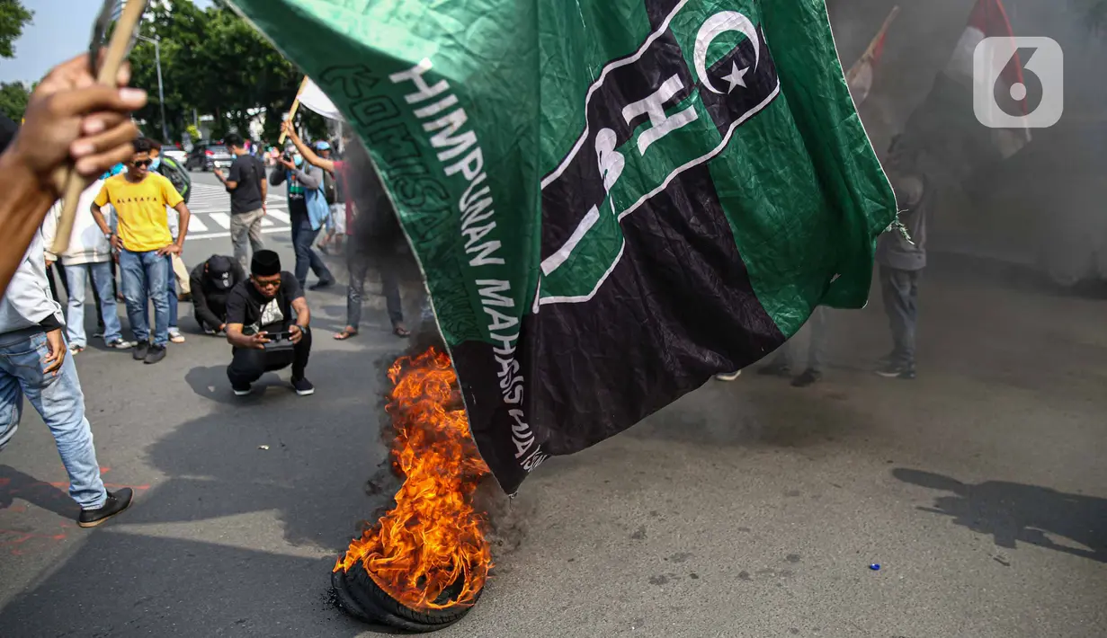 Massa Himpunan Mahasiswa Islam (HMI) membakar ban bekas saat berunjuk rasa menentang UU Cipta Kerja di kawasan Patung Kuda, Jakarta, Rabu (28/10/2020). Massa meminta Presiden Joko Widodo segera mencabut UU Cipta Kerja melalui Peraturan Pemerintah Pengganti Undang-Undang. (Liputan6.com/Faizal Fanani)