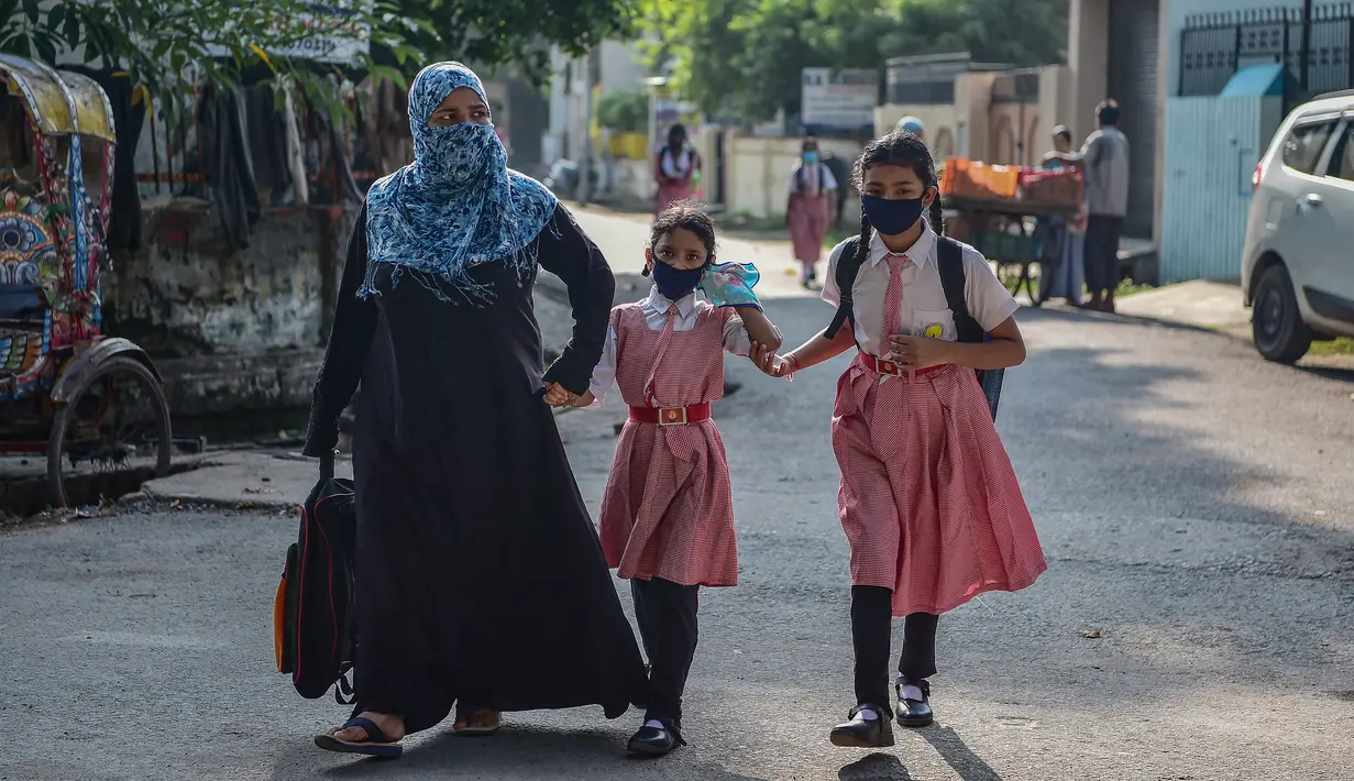 Siswa berjalan menuju sekolah mereka di Allahabad, India, Rabu (1/9/2021). Pemerintah negara bagian melonggarkan lockdown COVID-19 untuk lembaga pendidikan yang memungkinkan siswa menghadiri sekolah tatap muka dengan 50 persen kapasitas. (SANJAY KANOJIA/AFP)