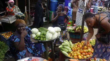 Para perempuan menjual sayuran di pasar Kaporo di Conakry, Guinea Senin (13/9/2021). Pasukan elit militer Guinea melakukan kudeta dan menangkap Presiden Alpha Conde pada Minggu, 5 September lalu. (AP Photo/ Sunday Alamba)