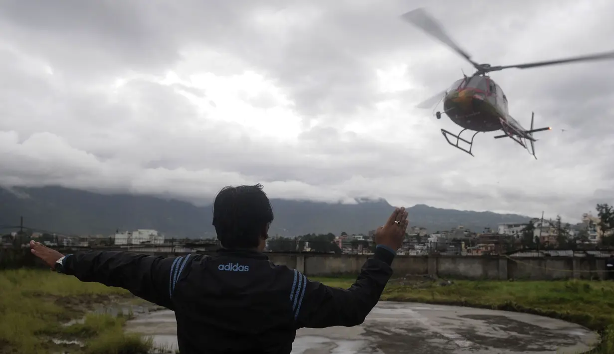 Petugas mengarahkan helikopter yang membawa korban tewas setibanya di sebuah rumah sakit di Ibu Kota Nepal, Kathmandu, Senin (8/8). Tujuh orang, termasuk bayi dan pilot tewas akibat jatuhnya Helikopter Fishtail Air. (AFP PHOTO/BIKASH Karki)