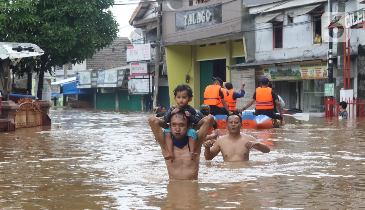 Warga melintasi banjir di perumahan Ciledug Indah, Tangerang, Rabu (1/1/2020). Banjir setinggi dada orang dewasa terjadi akibat meluapnya kali angke. (Liputan6.com/Angga Yuniar)