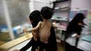 Seorang wanita menggendong anaknya saat berada di rumah sakit di Sanaa, Yaman pada 27 September 2016. Bangsal perawatan intensif di rumah sakit Yaman dipenuhi dengan anak-anak malnutrisi. (REUTERS/Khaled Abdullah)