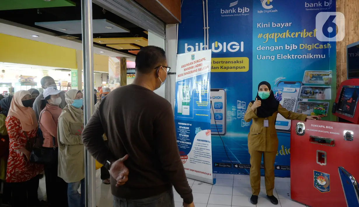 Petugas memberikan penjelasan kepada warga yang akan melakukan pencetakan di mesin Anjungan Dukcapil Mandiri (ADM) di Pamulang Square, Tangerang Selatan, Senin (15/9/2020). Warga dapat melakukan pelayanan kependudukan tanpa perlu lagi datang ke kantor Disdukcapil di ADM. (merdeka.com/Dwi Narwoko)