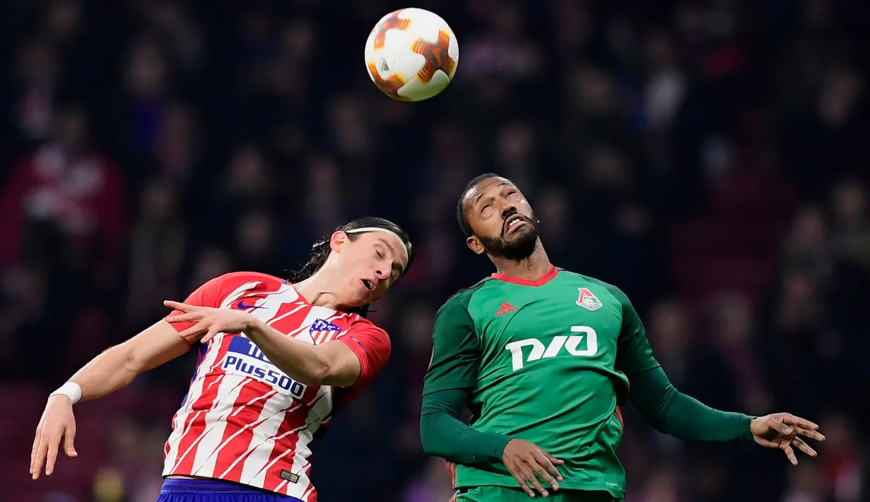 Bek Atletico Madrid Filipe Luis berebut bola di udara dengan pemain Lokomotiv Moskow Manuel Fernandes saat pertandingan Liga Europa leg pertama di stadion Wanda Metropolitano, Madrid (8/3). Atletico menang 3-0 atas Lokomotiv Moscow. (AFP/Javier Soriano)