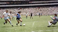 Penyerang Argentina, Diego Maradona, mencetak gol ke gawang Inggris pada laga perempat final Piala Dunia 1986 di Meksiko, (29/6/1986). (Photo by - / AFP)