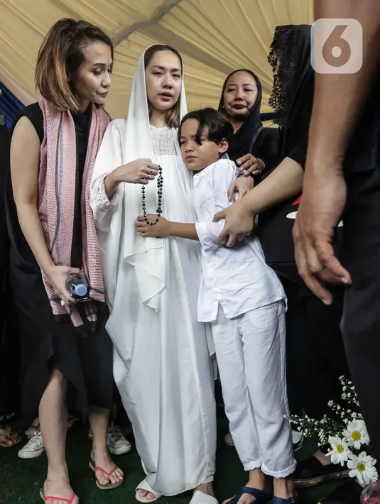 Bunga Citra Lestari atau BCL memeluk anaknya Noah Sinclair saat pemakaman jenazah Ashraf Sinclair di San Diego Hills, Karawang, Jawa Barat, Selasa (18/2/2020). Keluarga dan kerabat mengiringi pemakaman jenazah Ashraf Sinclair. (Liputan6.com/Faizal Fanani)