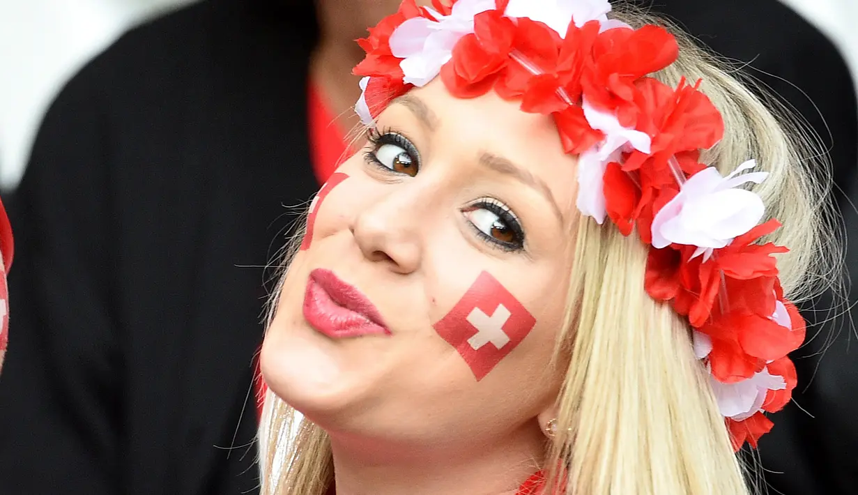 Fans asal  Swiss tersenyum manis saat tertangkap kamera di tribun pada laga grup A Prancis vs Swiss Euro 2016 di Stadion Pierre-Mauroy, Lille (20/6/2016) WIB. (AFP/Francois Lo Presti)