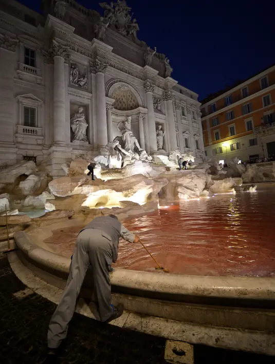 Petugas membersihkan air mancur Trevi di Roma, Italia usai aksi seorang pria menuangkan pewarna merah, 26 Oktober 2017. Pejabat Kota Roma mengecek lokasi untuk memastikan apakah ada kerusakan di tempat wisata dari abad ke-18 ini. (Filippo MONTEFORTE/AFP)