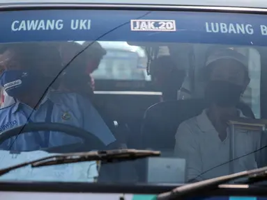 Sopir angkutan umum Jak Lingko mengenakan masker dan sarung tangan di kawasan Cawang, Jakarta, Senin (6/7/2020). Pada perpanjangan masa PSBB transisi, angkutan umum sudah mulai beroperasi kembali dengan menerapkan protokol Kesehatan Covid-19. (Liputan6.com/Faizal Fanani)