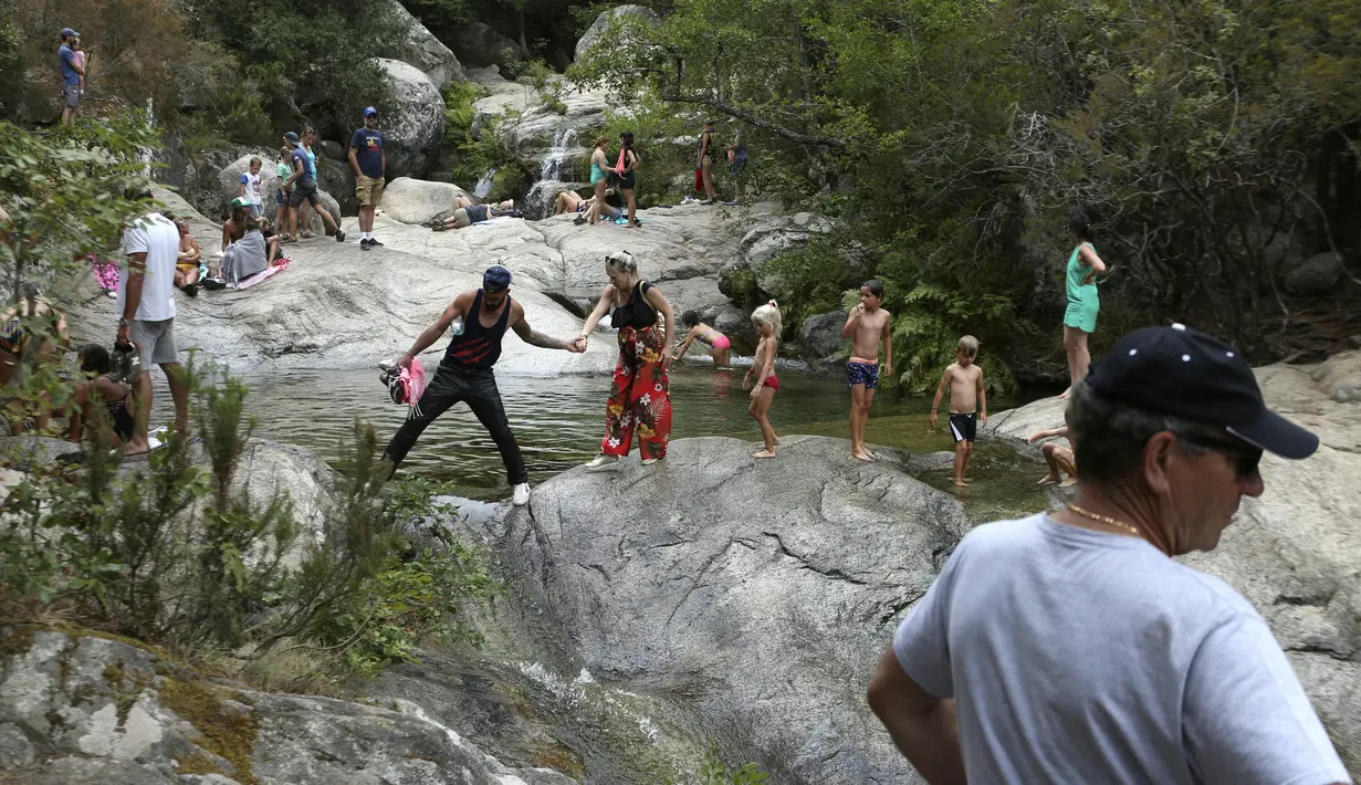 Wisatawan menikmati kolam alami Polischellu di hutan Bavella di celah Bavella dekat Zonza di selatan pulau Corsica, Mediterania Prancis (25/8/2021).  Situs Bavella penuh sesak dengan turis selama musim panas. (AFP/Pascal Pochard-Casabianca)
