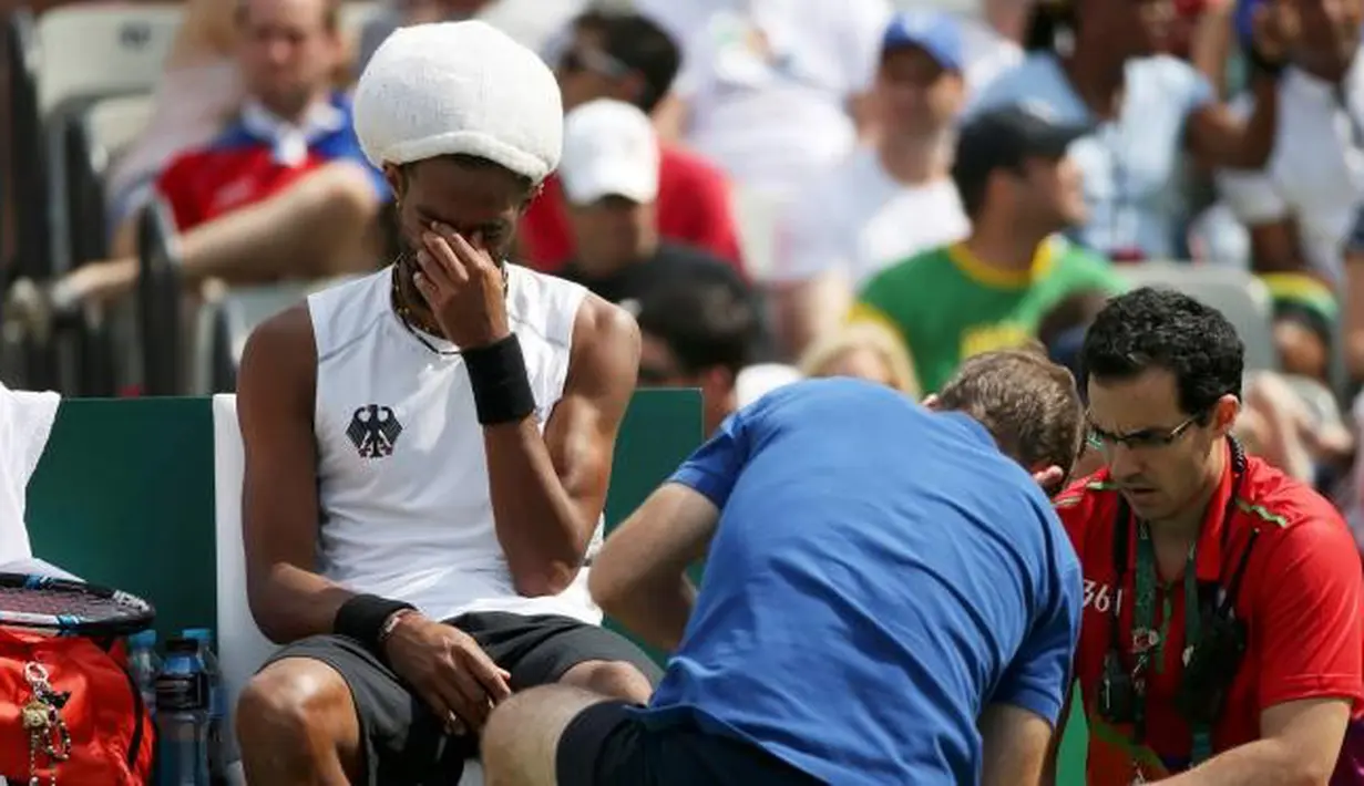 Petenis asal Jerman, Dustin Brown menangis saat tim medis mengobati cidera yang di alaminya saat bertanding di Olimpiade Rio 2016 melawan Thomaz Bellucci asal Brasil, Brasil (7/8). (REUTERS/Kevin Lamarque)