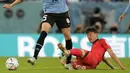 Pemain Korea Selatan, Lee Jae-sung (kanan) berusaha menghentikan laju pemain Uruguay, Federico Valverde. (AP Photo/Lee Jin-man)