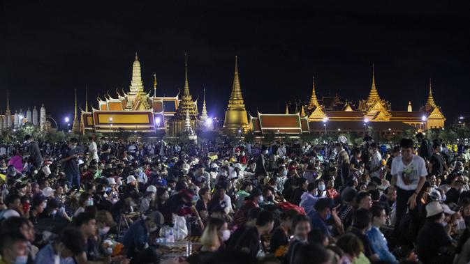 Demonstran pro-demokrasi menghadiri protes di Sanam Luang dengan The Grand Palace menyala di latar belakang di Bangkok, Thailand (19/9/2020). (AP Photo/Sakchai Lalit)