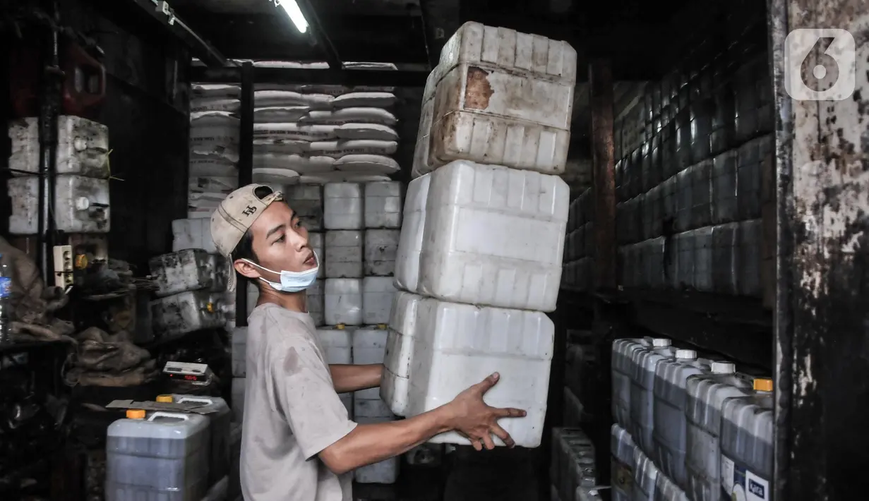 Pekerja merapikan jeriken berisi minyak goreng di kawasan Pasar Kebayoran Lama, Jakarta, Rabu (25/5/2022). Keputusan mencabut subsidi minyak goreng curah akan diambil setelah dua aturan baru terkait tindak lanjut pembukaan ekspor minyak goreng dan bahan baku turunannya diterbitkan. (merdeka.com/Iqbal S Nugroho)
