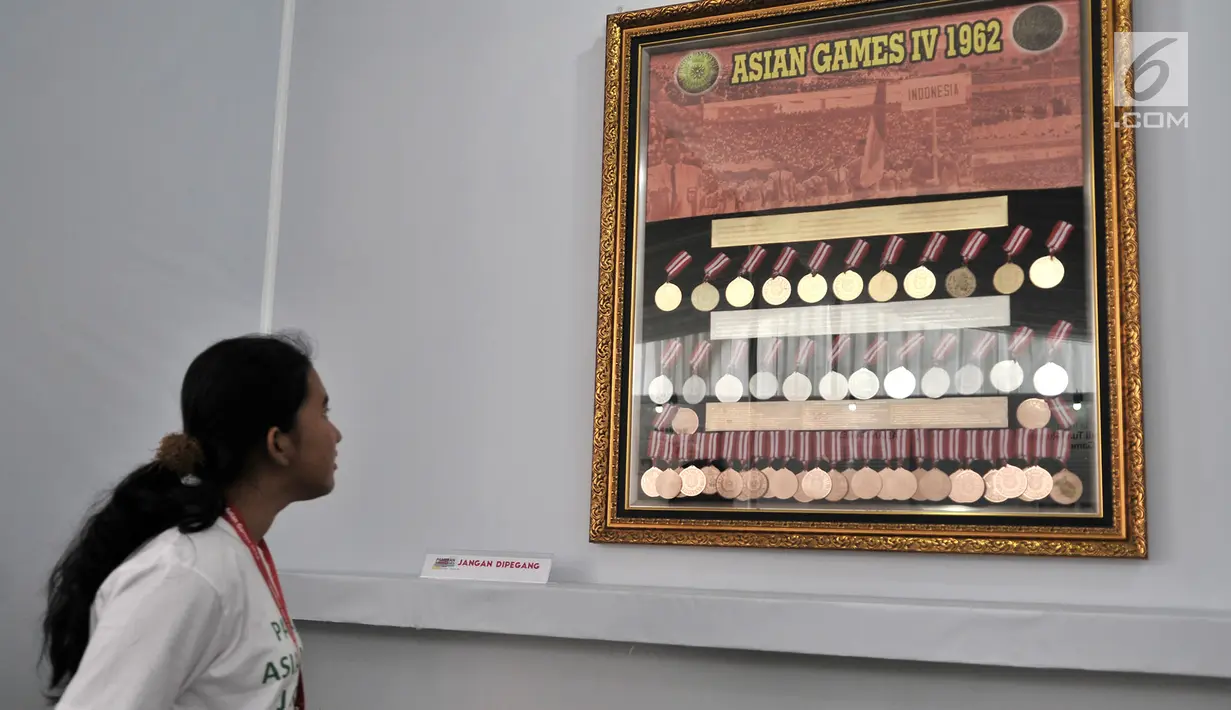Pengunjung melihat koleksi medali yang diraih atlet Indonesia pada Asian Games 1962 dalam pameran Asian Games di Museum Fatahillah, Kota Tua, Jakarta, Selasa (14/8). (Merdeka.com/Iqbal Nugroho)